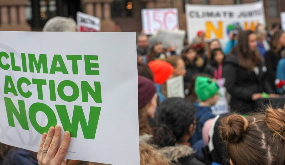 a crowd holding up climate change awareness signs